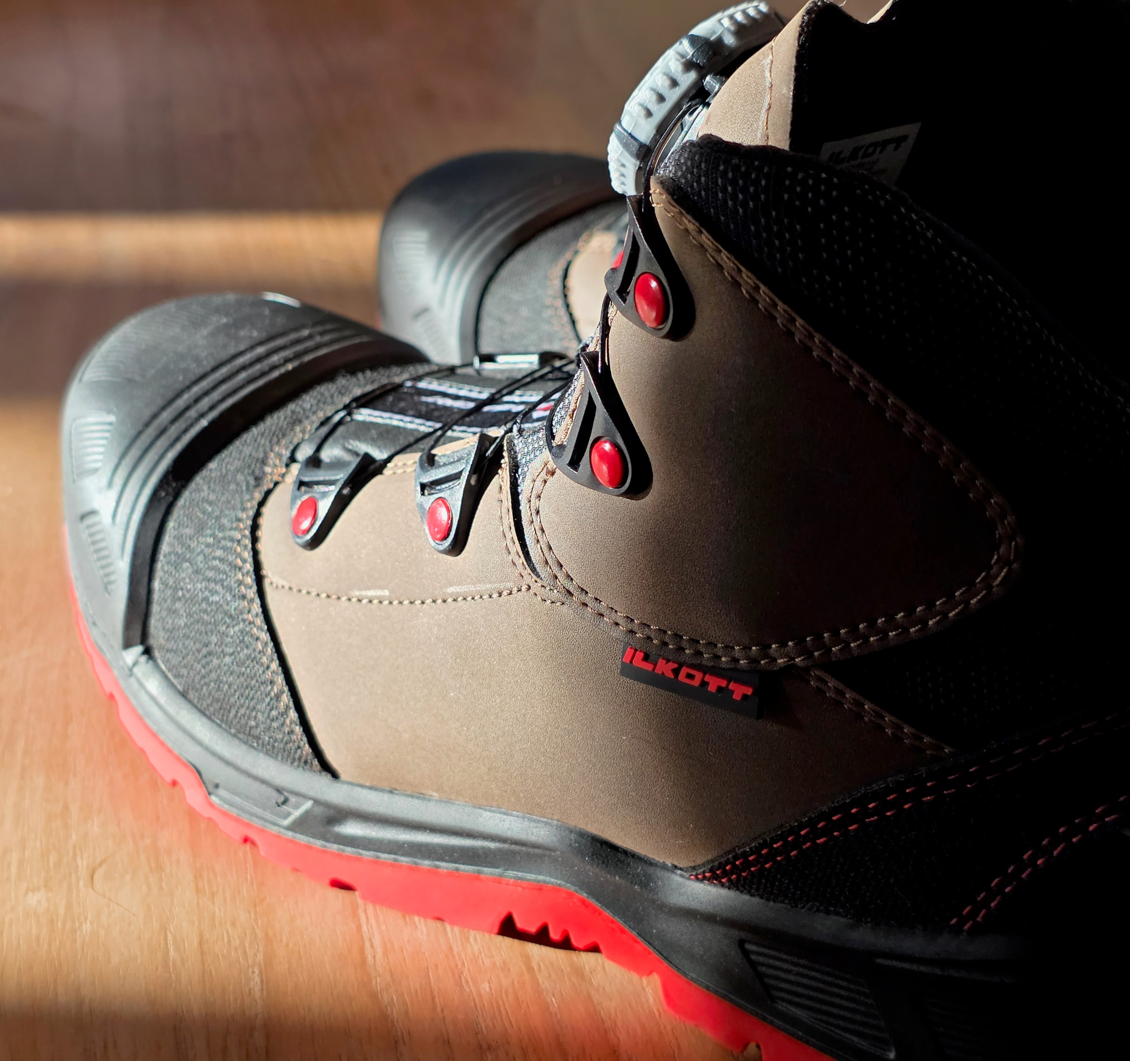 Profile view of the Ilkott Mid model G safety shoe, brown and black upper, red sole and dial lacing