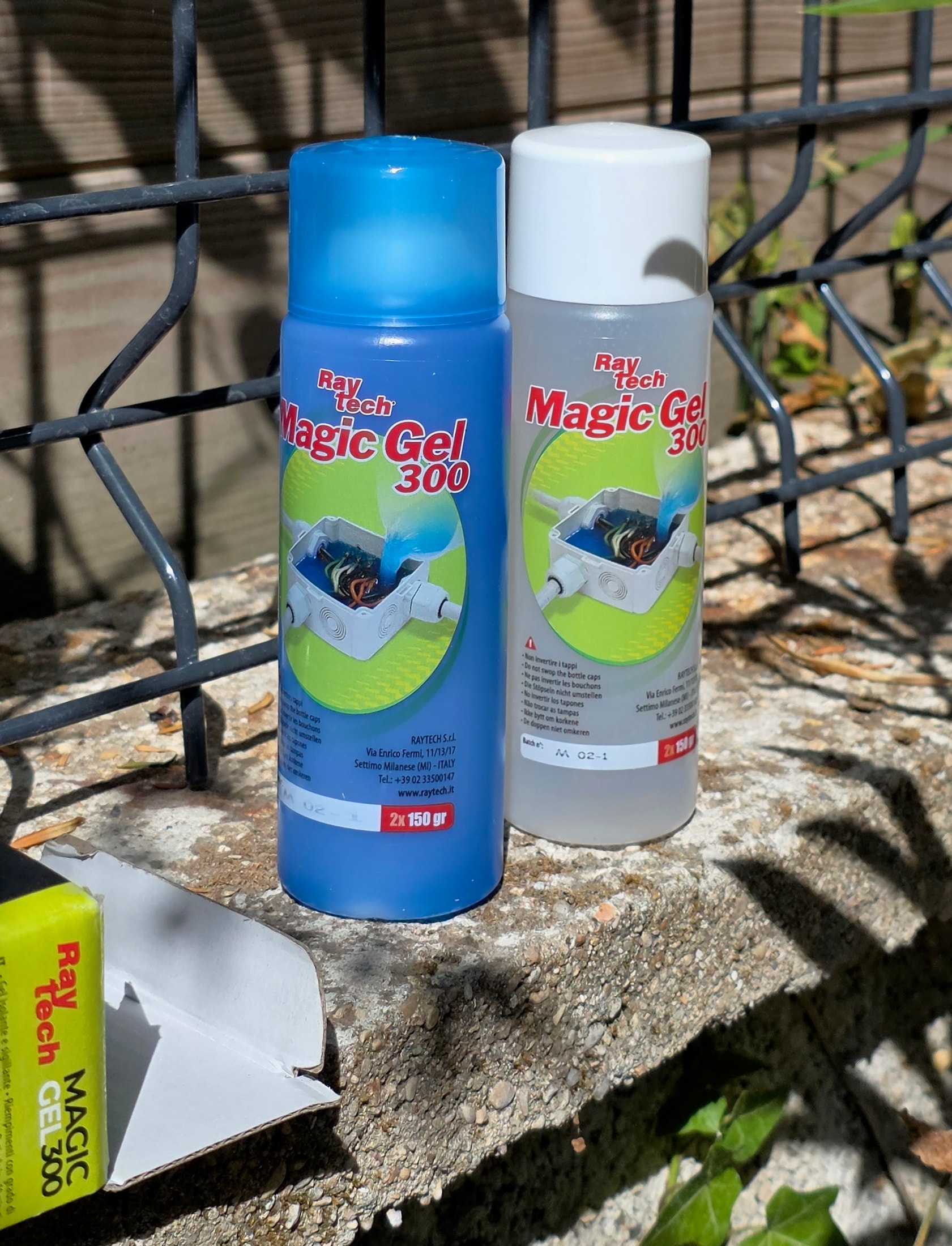 Due flaconi di Magic Gel 300 Raytech appoggiate su un muretto di cemento