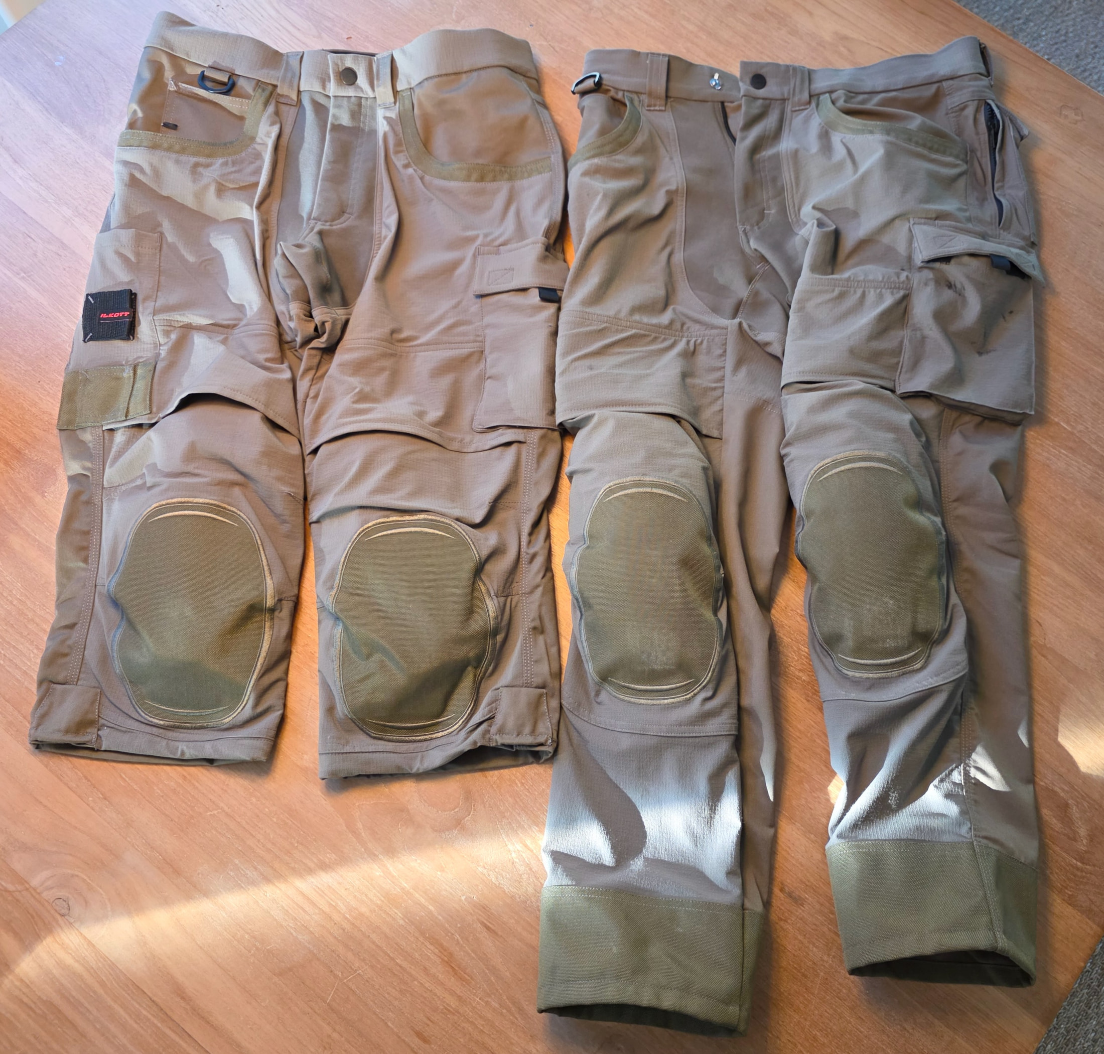 Due pantaloni da lavoro Ilkott con ginocchiere integrate e tasche multiple su un tavolo in legno chiaro