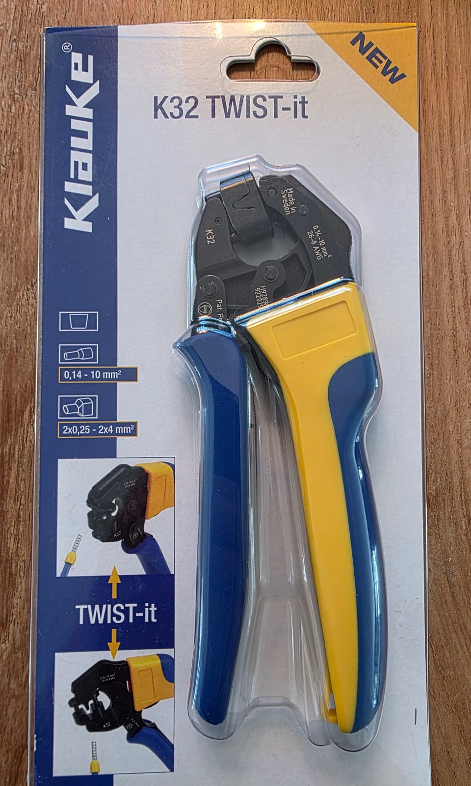 Embalaje blíster de la pinza Klauke K32 TWIST-it sobre una superficie de madera, rangos 0,14-10 mm² y 2x0,25-2x4 mm² visibles