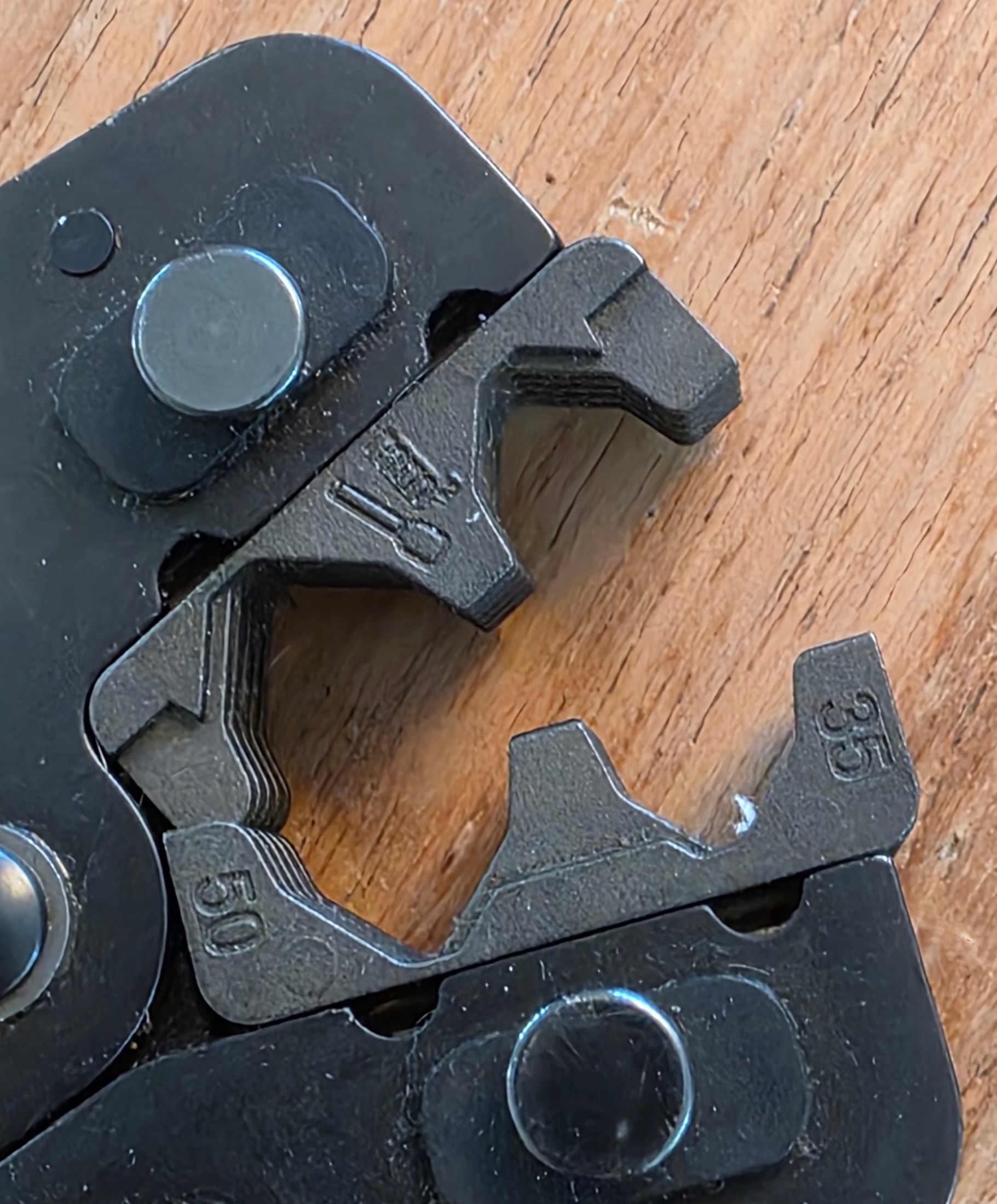 Primer plano de las mordazas de crimpado negras de una pinza Klauke con los grabados 35 y 50 en relieve