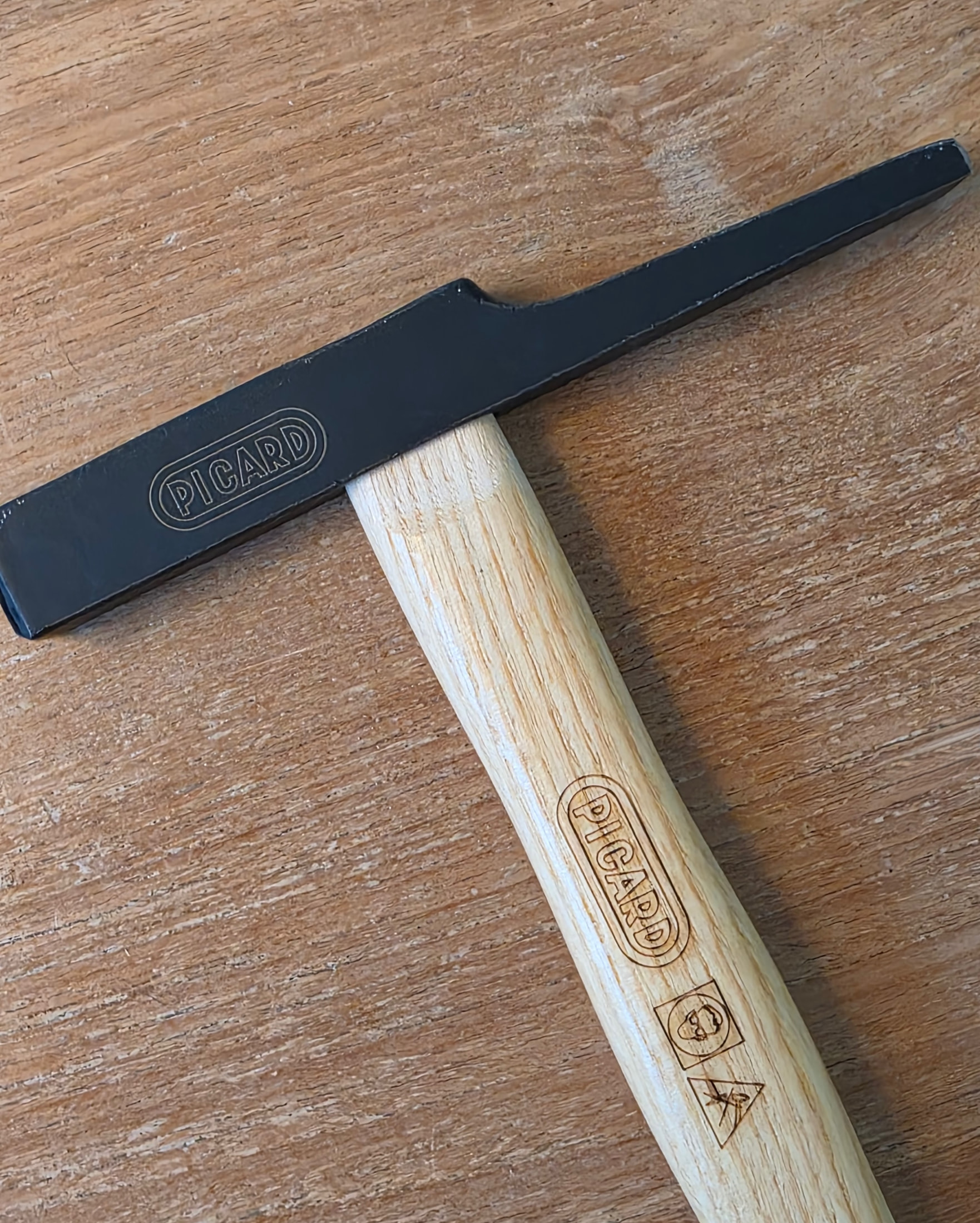 Close-up of the PICARD electrician’s hammer, ash handle and black head with engraved pictograms