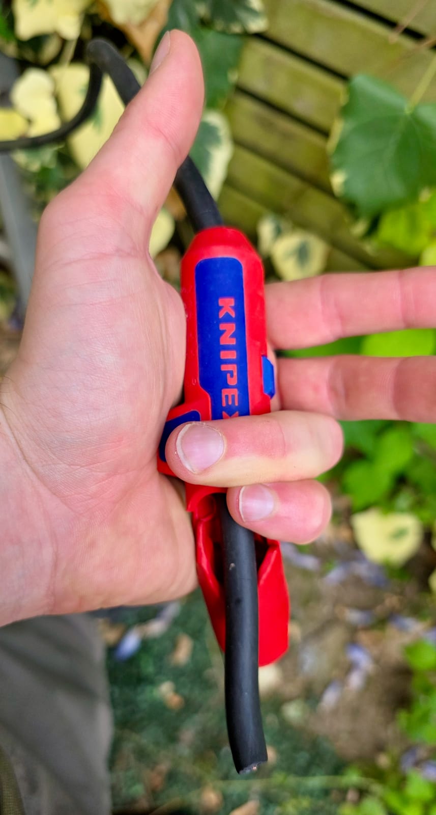 Knipex ErgoStrip tenuto in mano con un cavo R2V inserito durante la spellatura