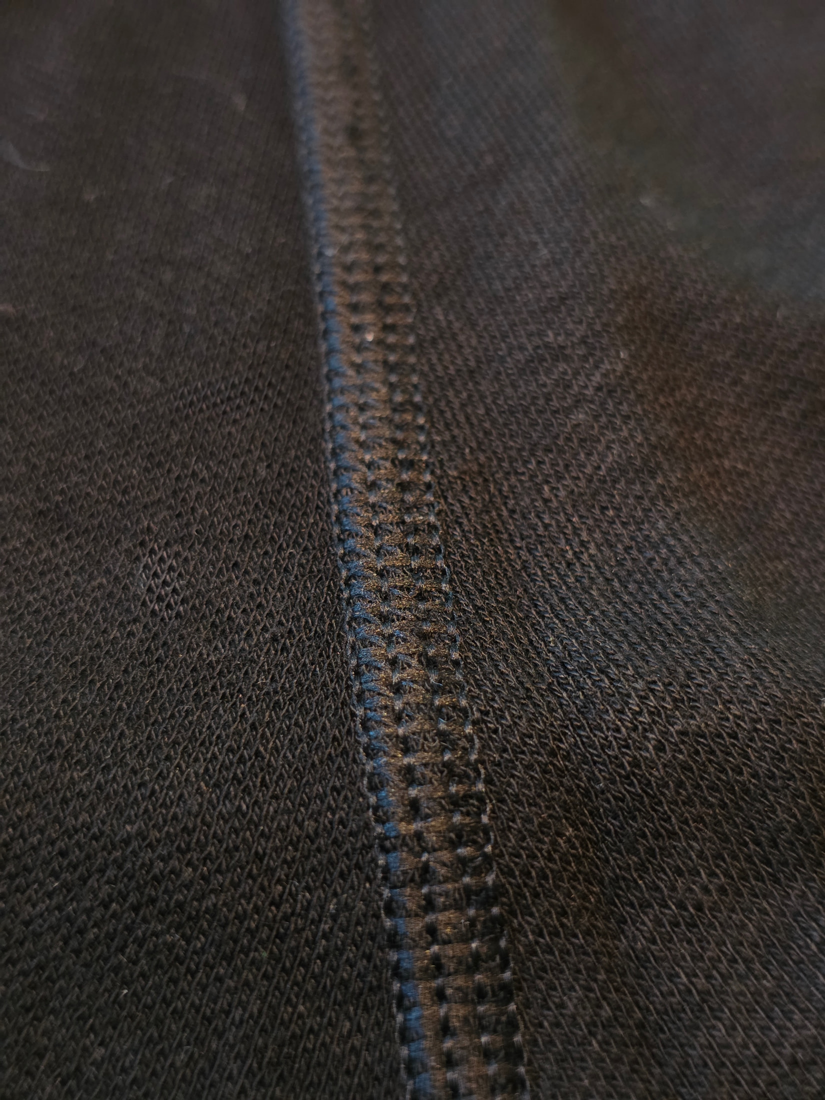 Macro della cucitura overlock sul tessuto nero in maglia fitta della calzamaglia Ilkott