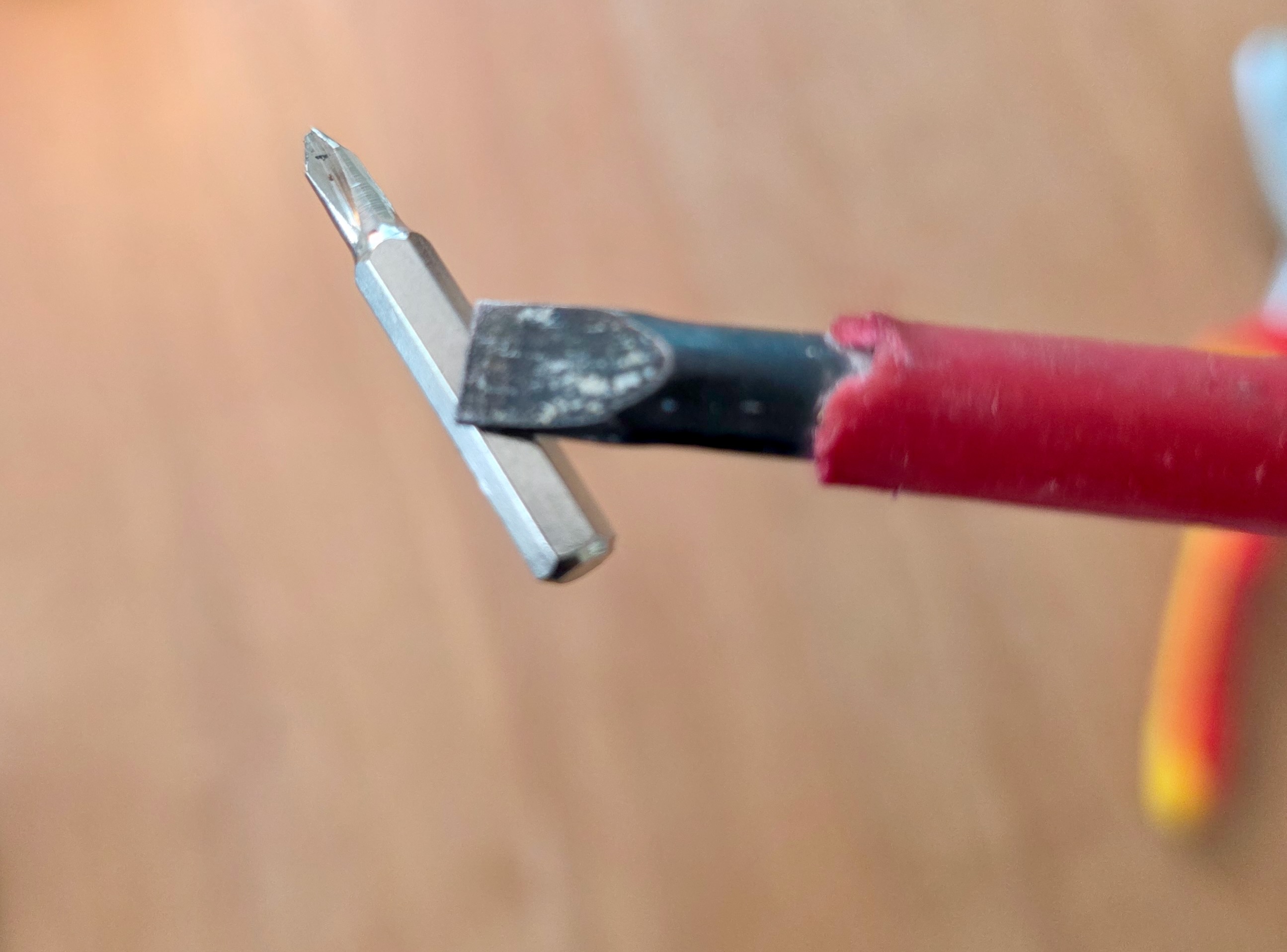 Primer plano de una punta de atornillar imantada que se queda pegada al vástago de un destornillador