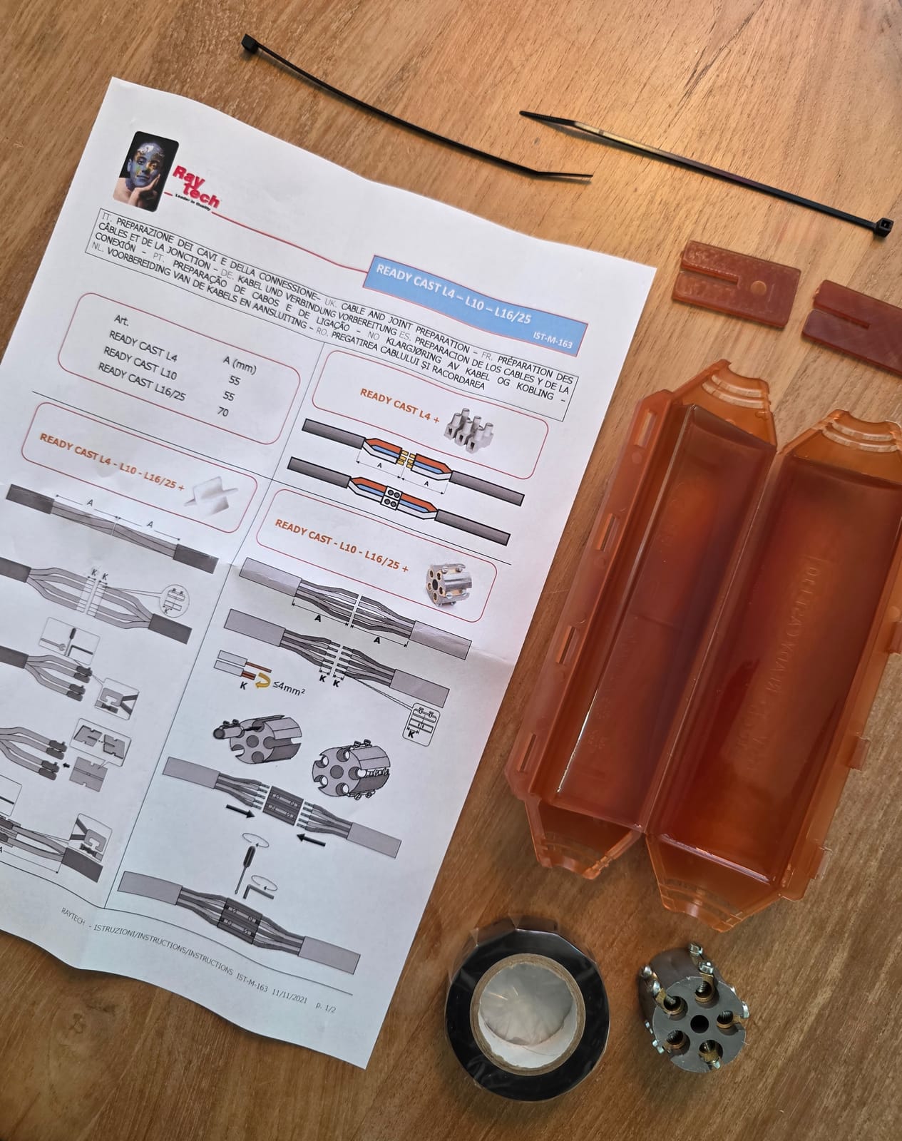 Foglio illustrativo della gamma Ready Cast L4, L10 e L16/25 appoggiato insieme ai componenti del kit su un tavolo di legno