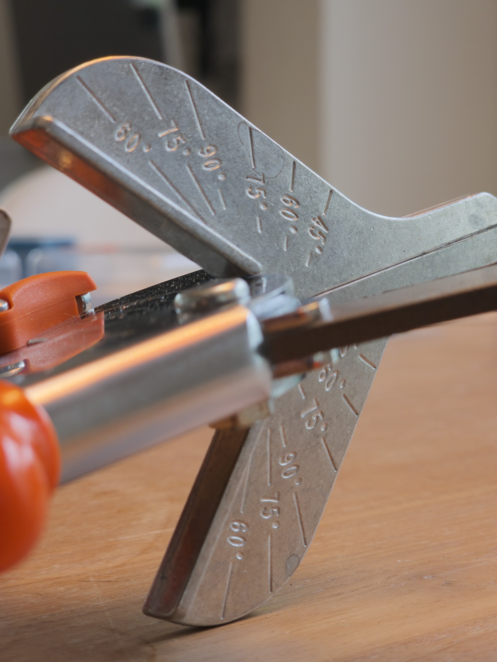 Tijeras para ingletes Original LÖWE 3.104 con tope angular graduado sobre mesa de madera