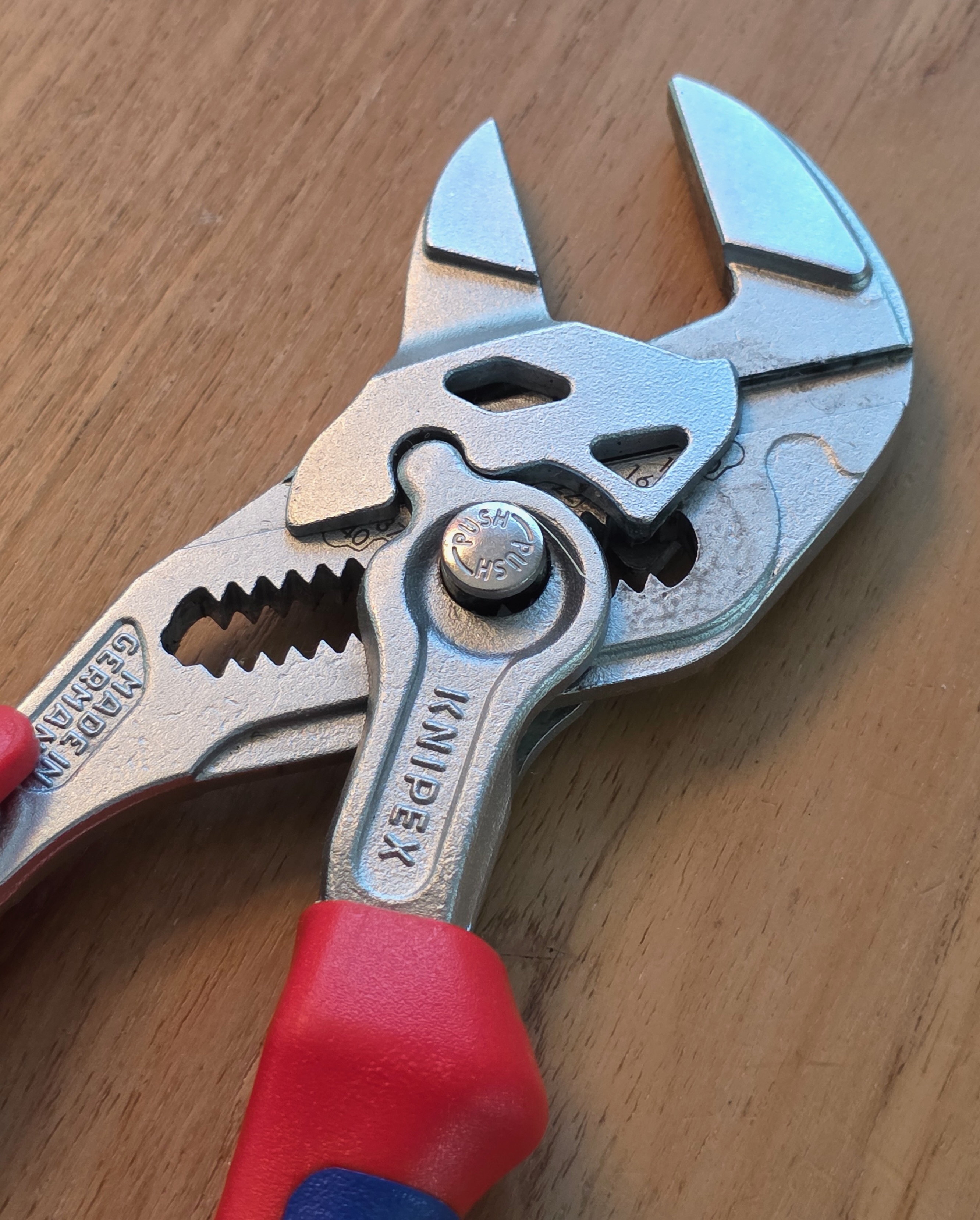 Primer plano de una llave-pinza Knipex de 180 mm vista de frente, con la mordaza y el marcado grabado visibles