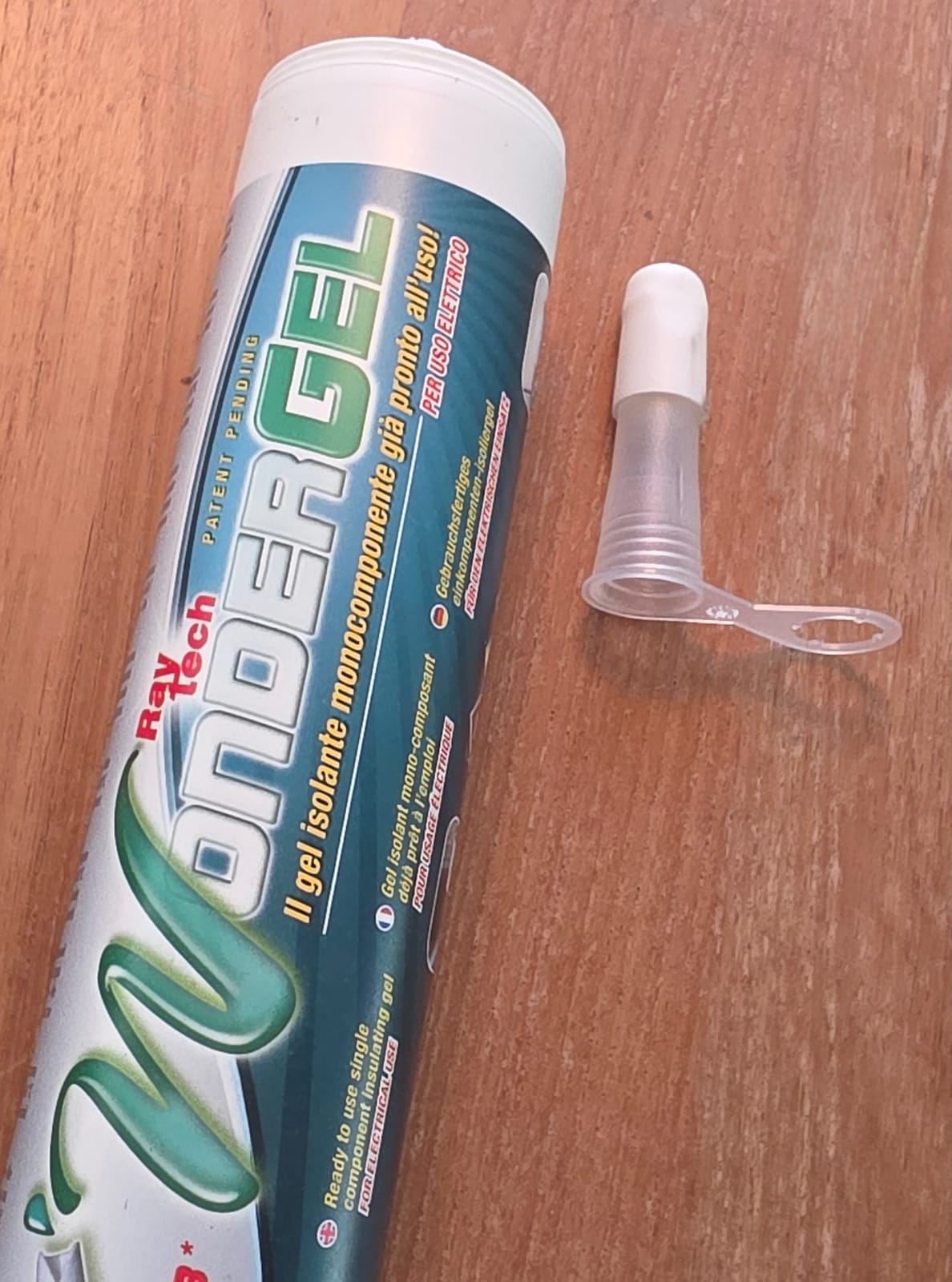 Cartuccia di Wonder Gel Raytech posata su un tavolo di legno con il suo beccuccio applicatore bianco staccato