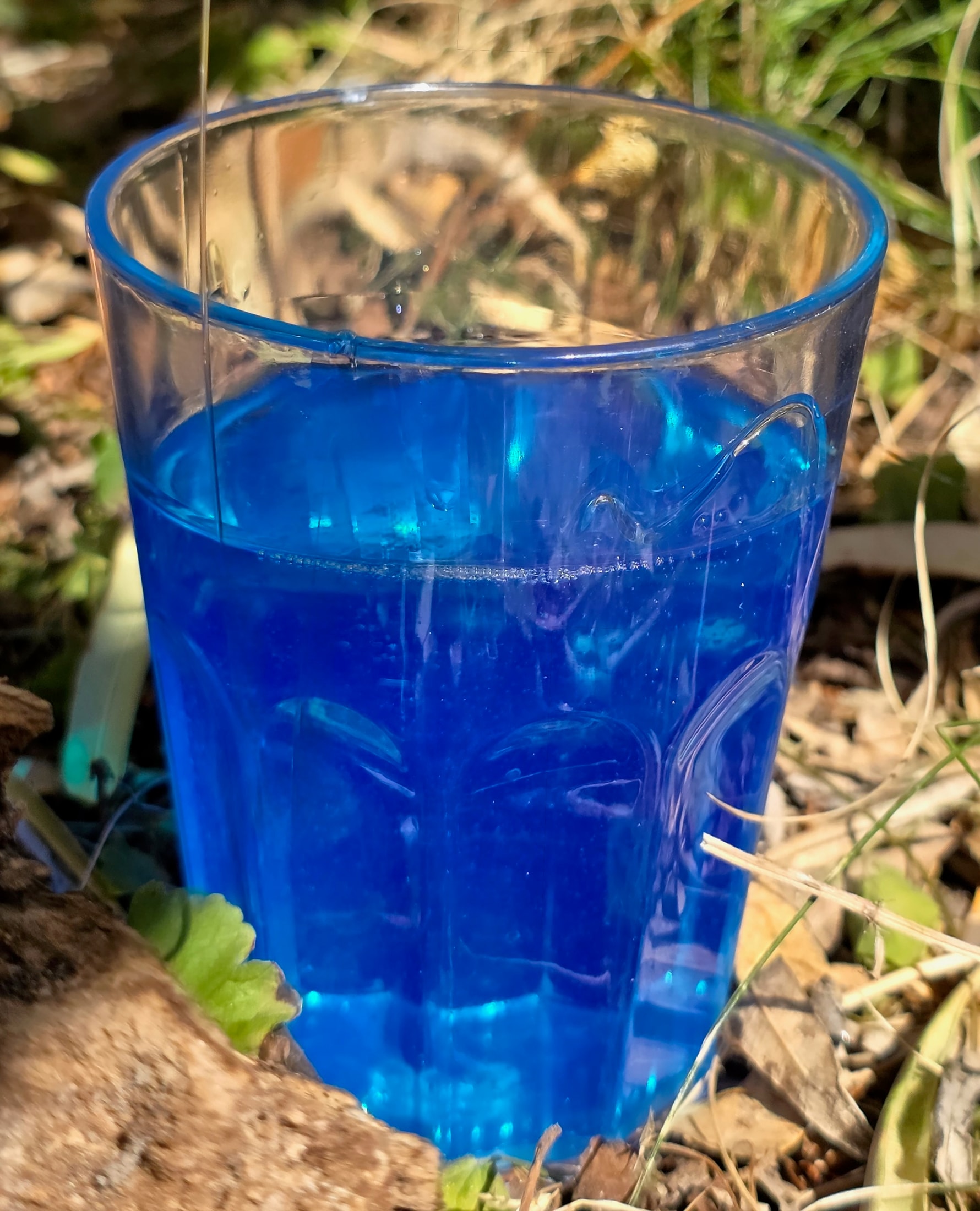 Bicchiere trasparente con Magic Gel isolante blu traslucido appoggiato a terra