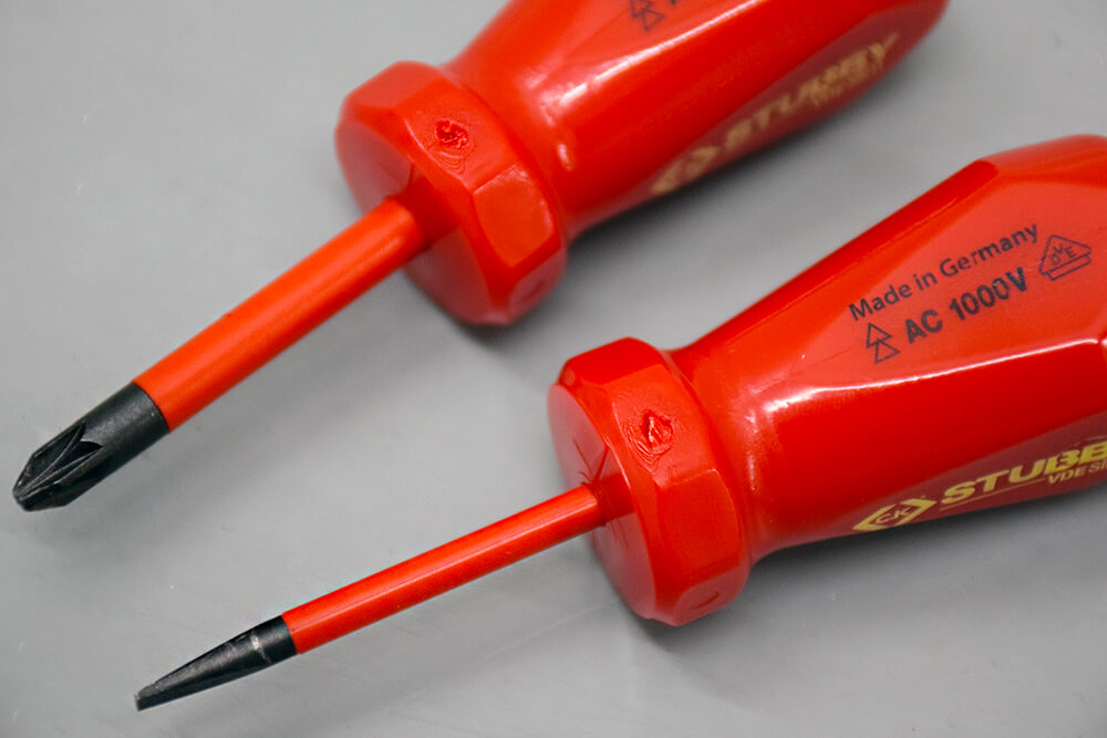 Primer plano de dos destornilladores con mango rojo y vástago naranja, con las inscripciones Made in Germany, AC 1000V y STUBBY.