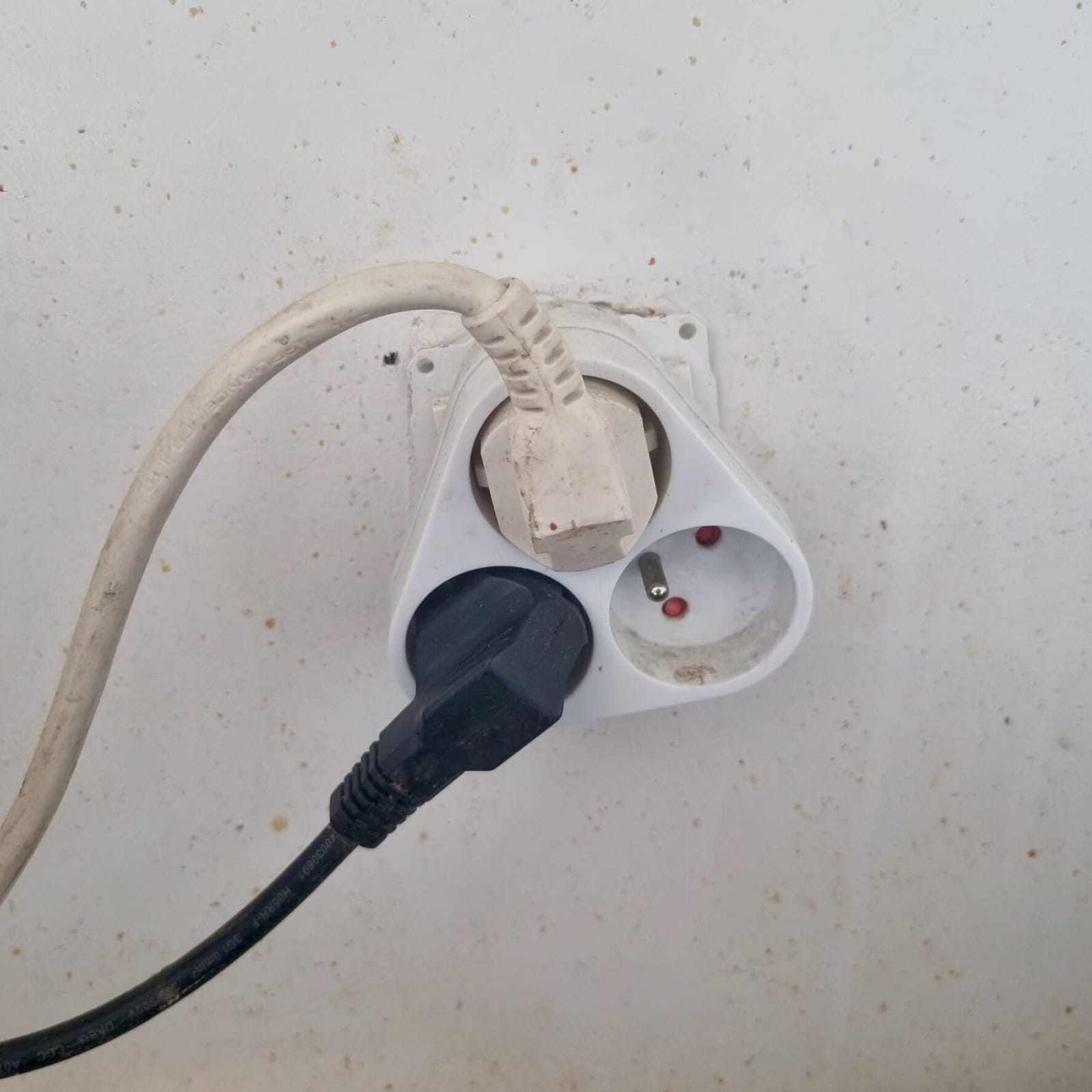 Multiprise surchargée branchée dans une prise murale, risque incendie
