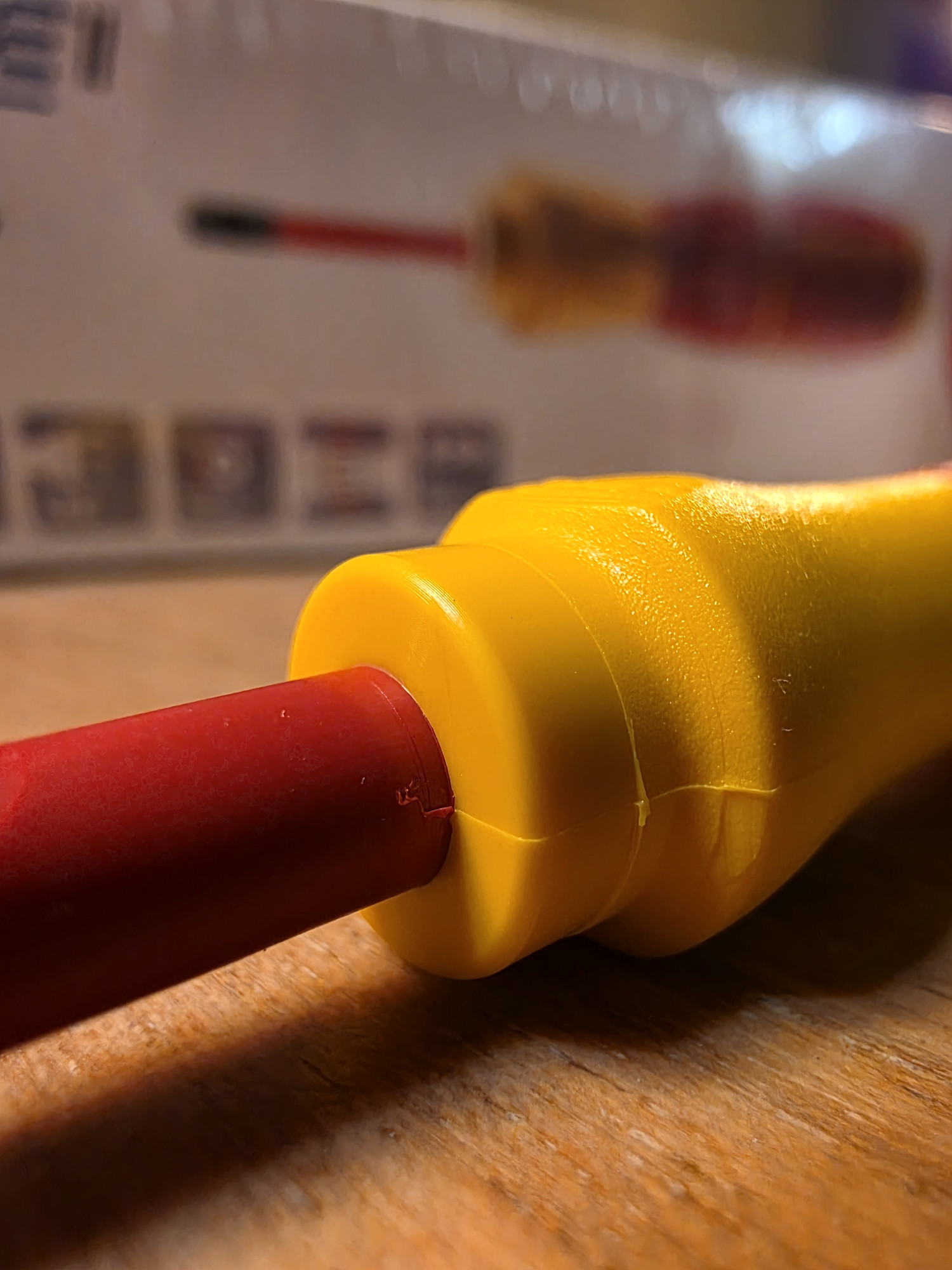 Giunzione visibile tra una guaina rossa e il manicotto giallo di un utensile Wiha