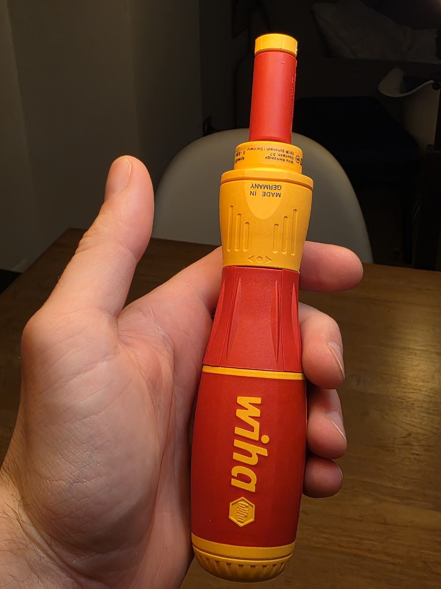 Cacciavite Wiha dinamometrico rosso e giallo appoggiato in una mano