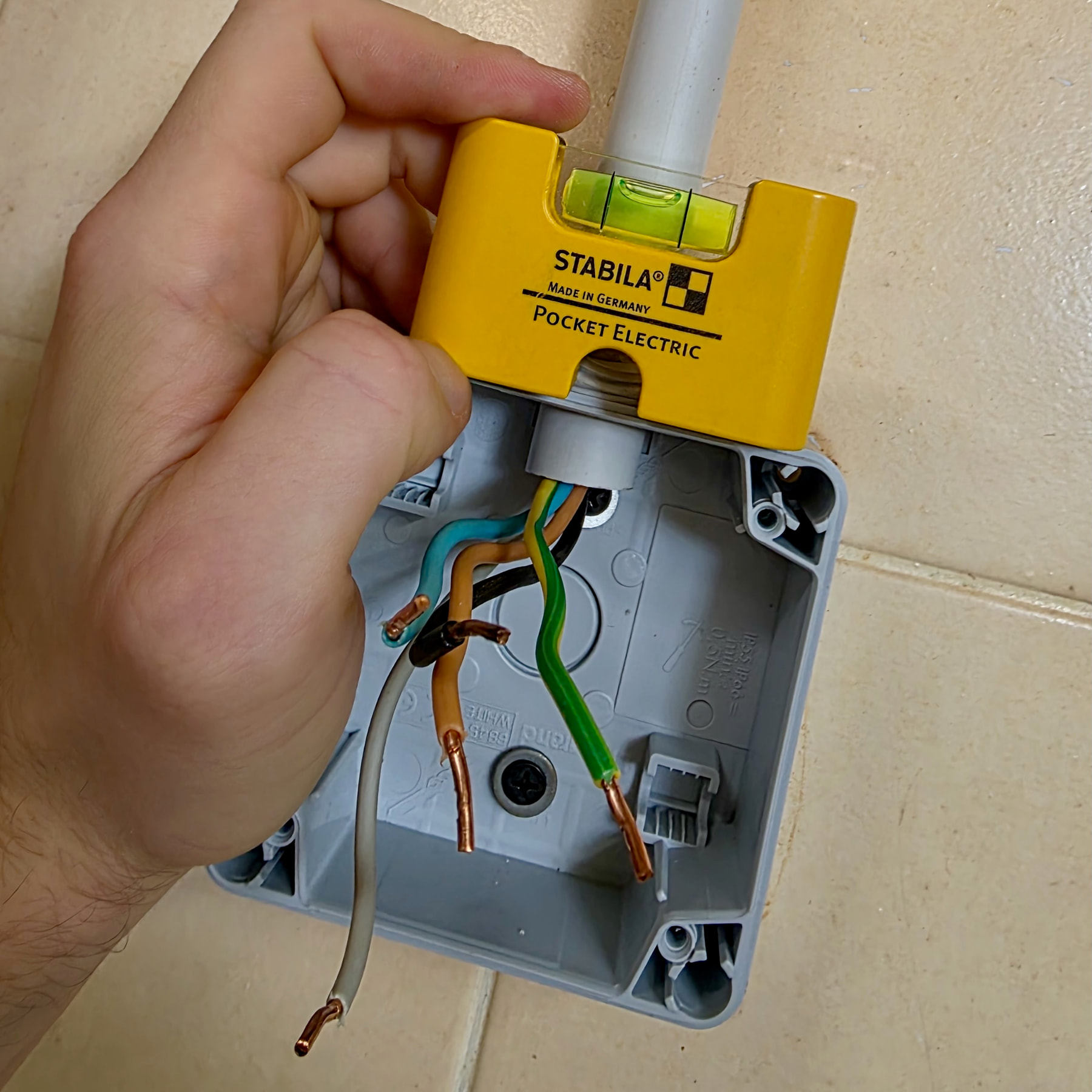 Socket back box levelled with a STABILA Pocket Electric level placed on top
