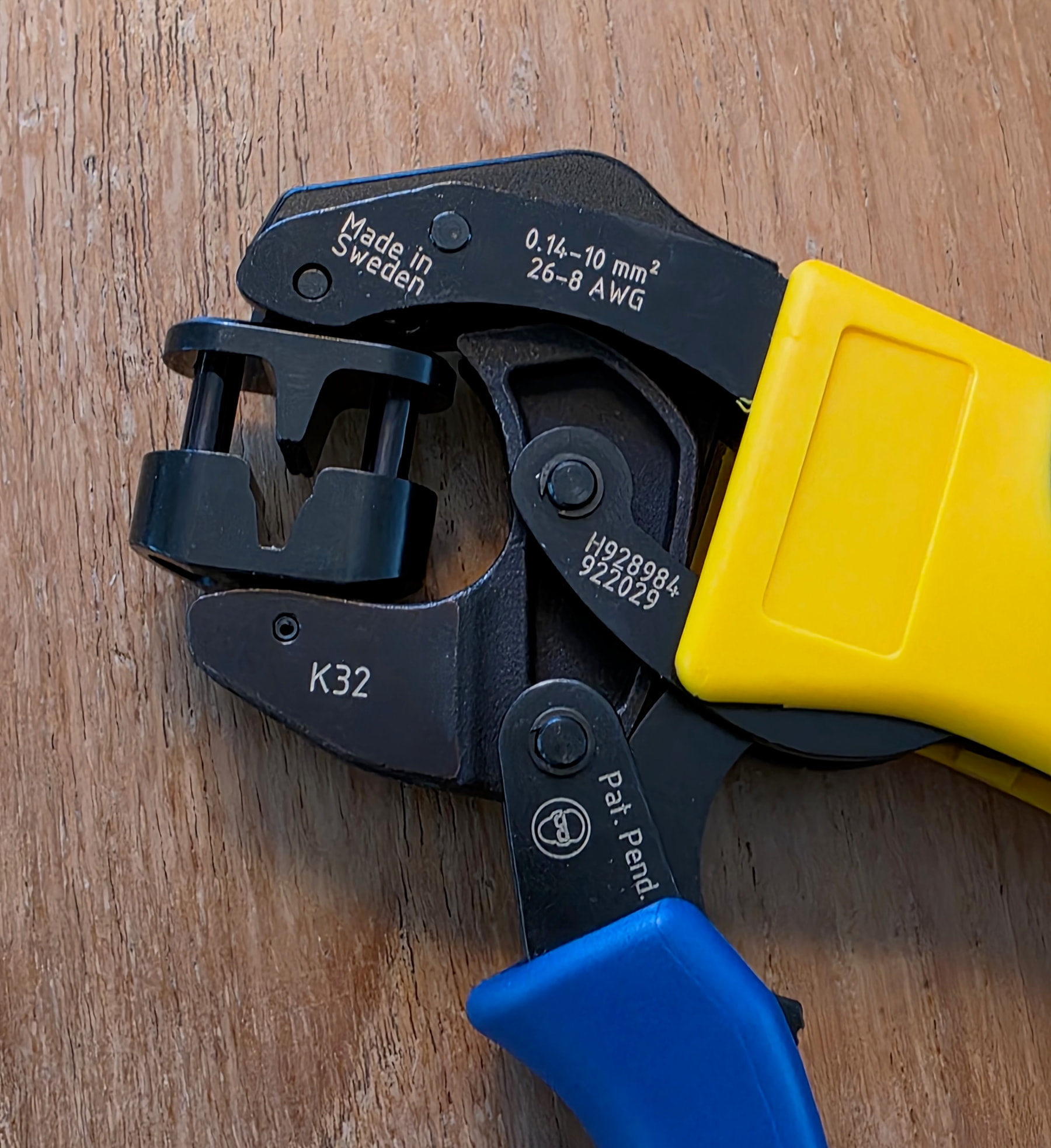 Cabeza de una pinza de crimpar Klauke K32 apoyada sobre una superficie de madera, grabado 10 mm² visible